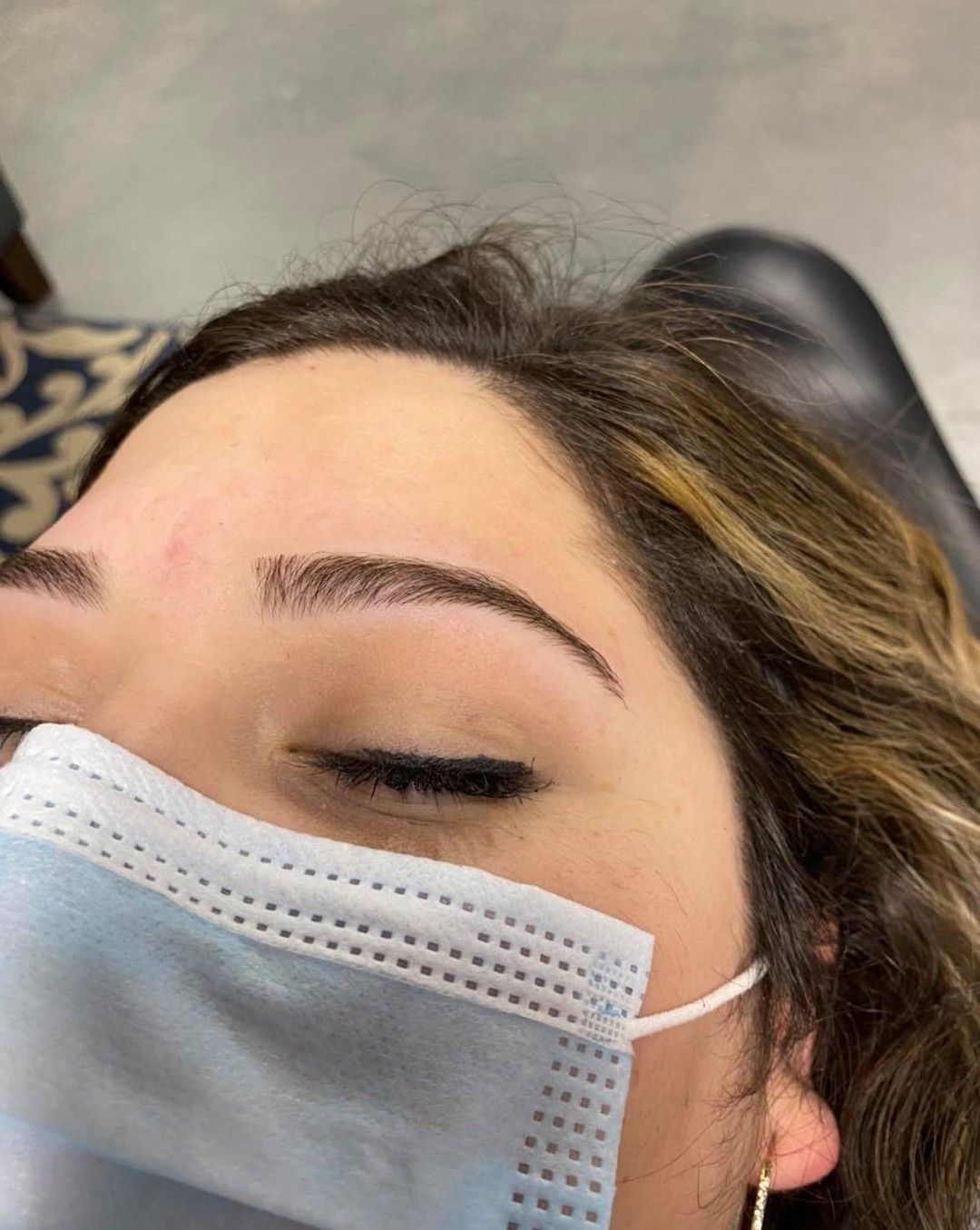 A woman is getting her eyelashes done at a beauty salon.