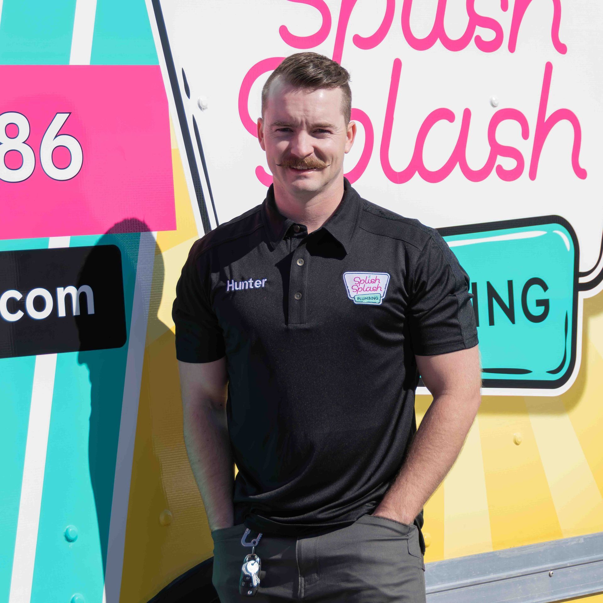 Man stands by pink & yellow truck with 