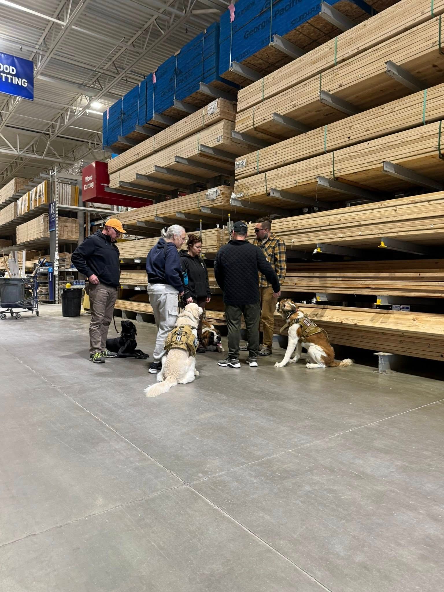 A group of people and a dog are standing in a warehouse.
