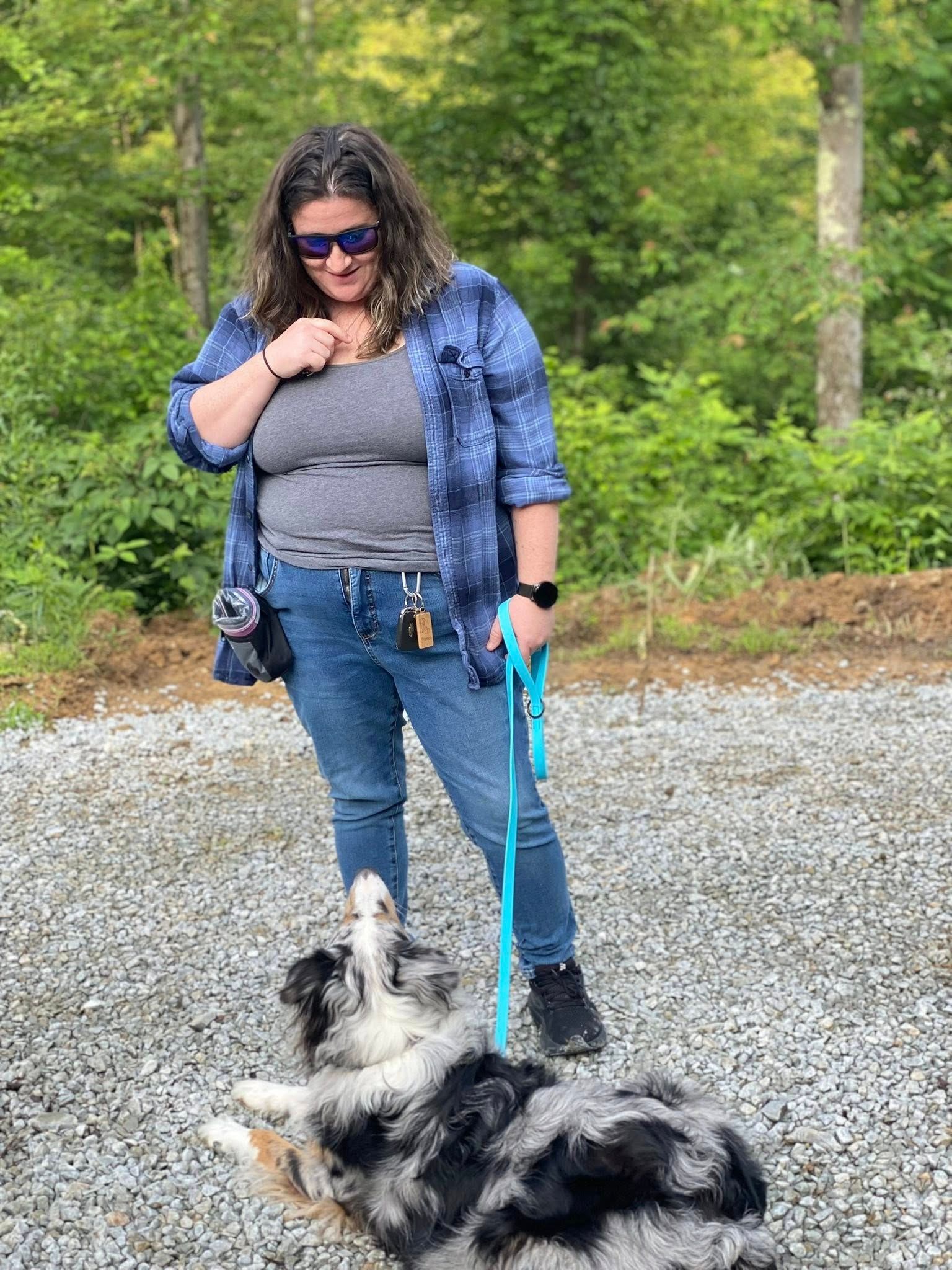 A woman is walking a dog on a leash.