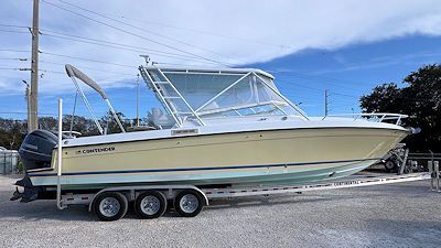 Yellow and white Contender boat on a trailer, blue sky in the background.