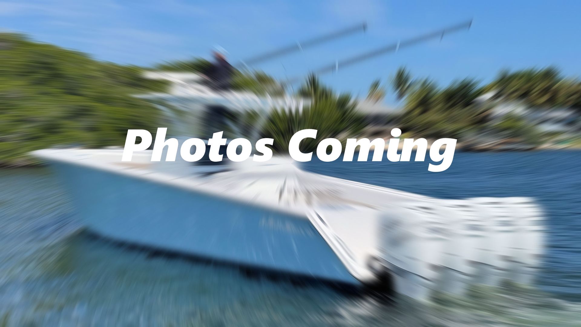 White yacht speeding across blue water with a blurred motion effect and “Photos Coming” text overlaid.