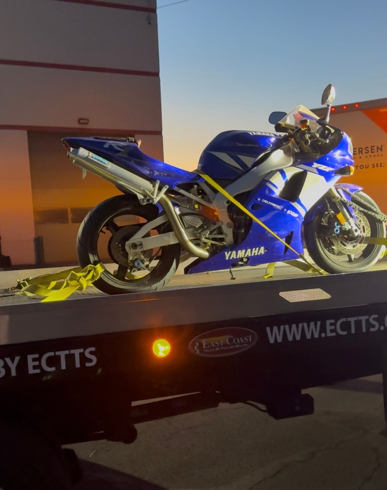 A blue yamaha motorcycle is on a tow truck
