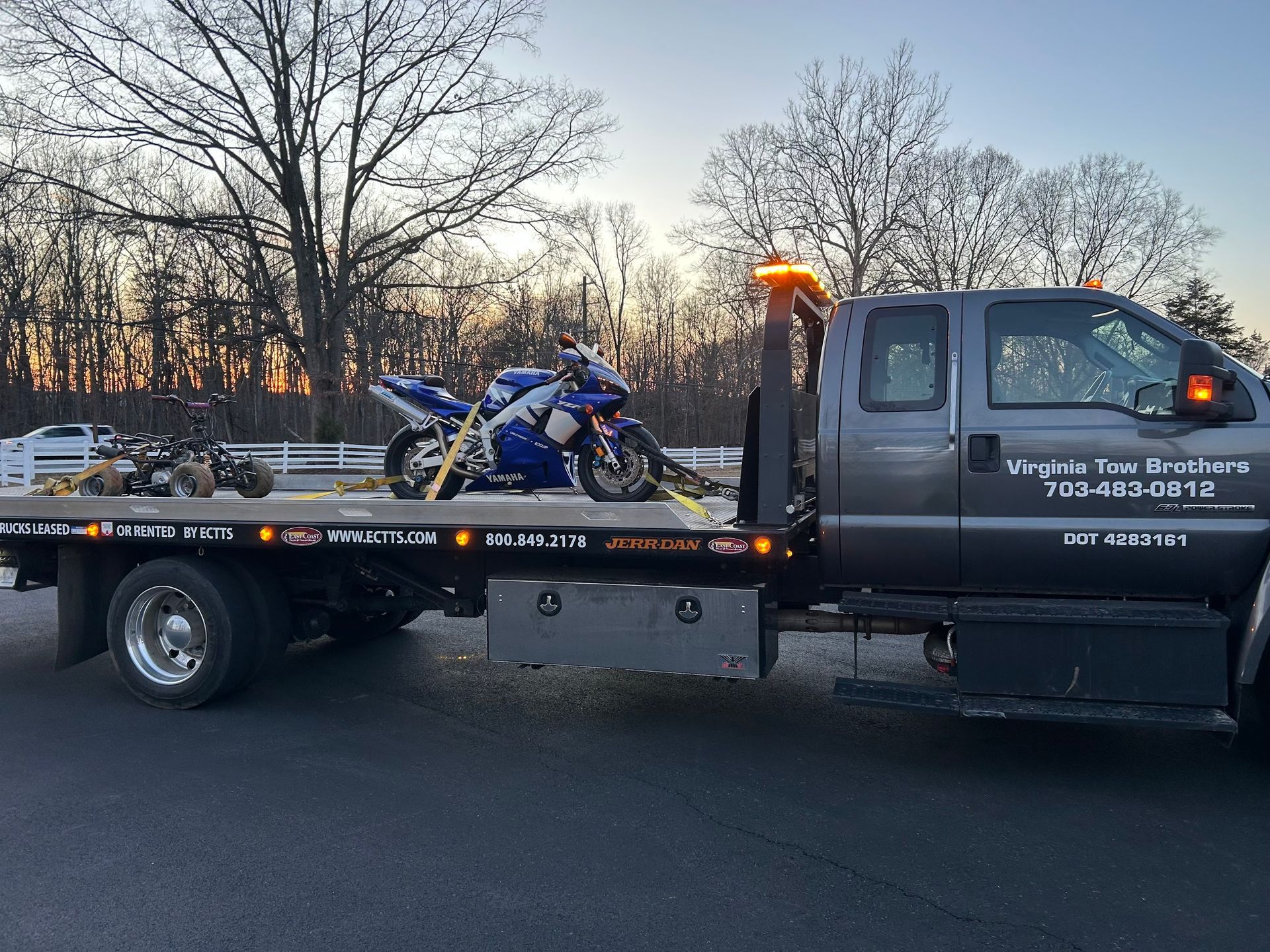 A tow truck with a motorcycle on the back of it