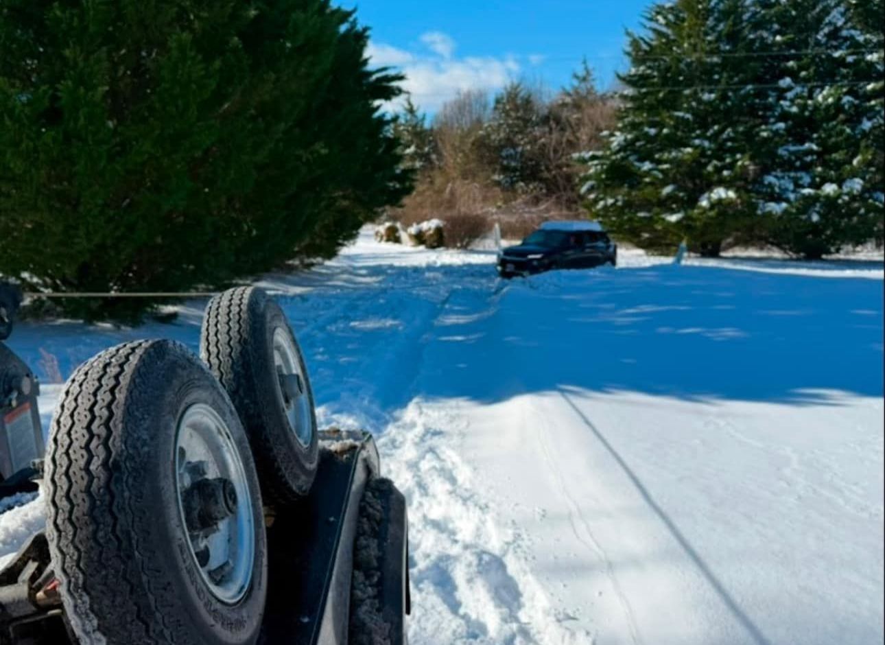A car is being towed by a trailer in the snow