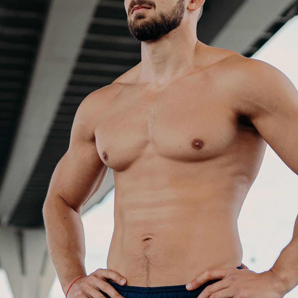 Person receiving intravenous fluids. Medical staff, gloved hands; arm on pillow with IV line and bandage.