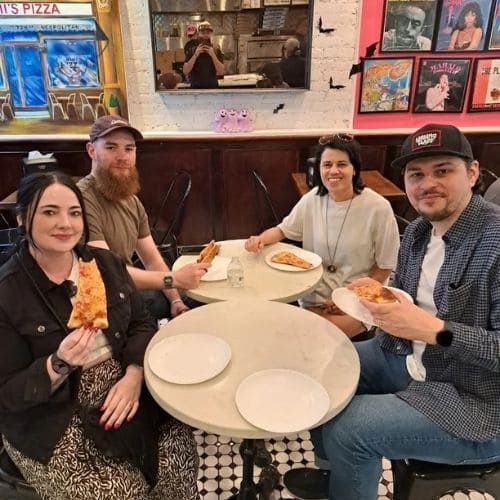 Guests eating a slice of pizza from Mimi's Pizza, Upper West Side