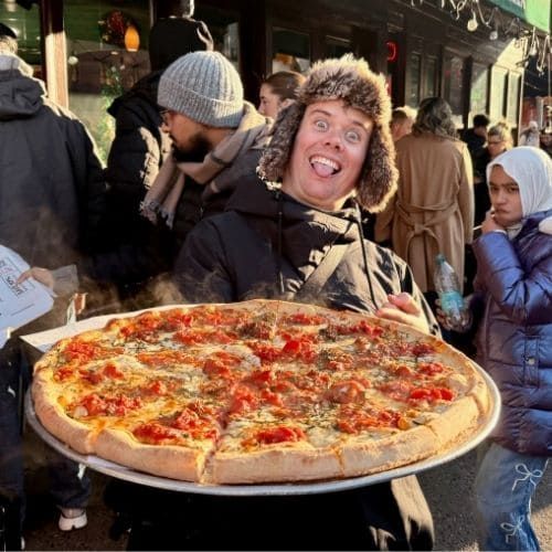 Tour Guide Ryan holding a pizza in Greenwich Village