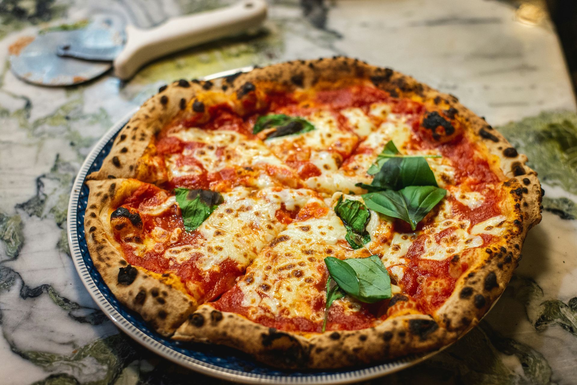 Margherita pizza with a charred crust, melted mozzarella, and fresh basil