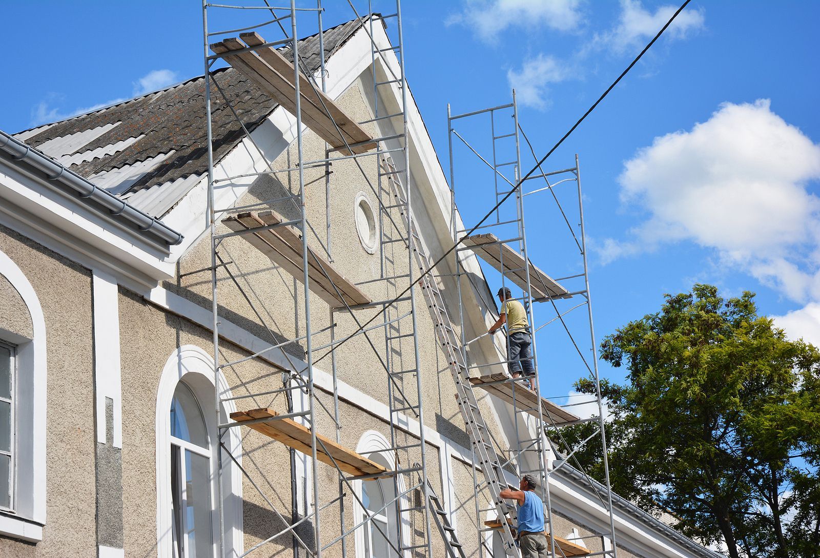 A building is being painted with scaffolding around it.