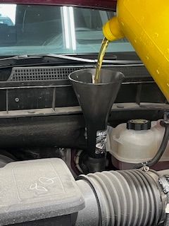 A man is working on the engine of a car in a garage.