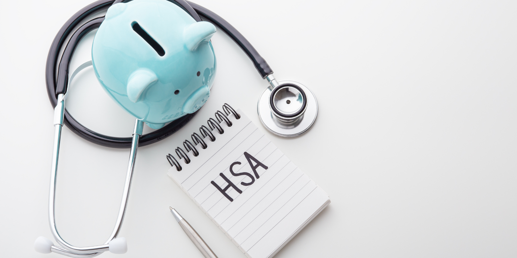 A piggy bank with a stethoscope and a notebook with the word hsa written on it.