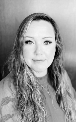 A black and white photo of a woman with long hair and a necklace.