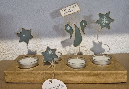 Kerzenhalter mit türkisfarbenen Sternen und Engelsverzierungen, vier Teelichtern und einem kleinen Schild.