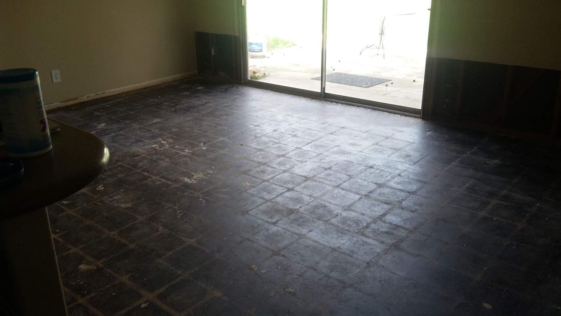 An empty room with a table and a sliding glass door.
