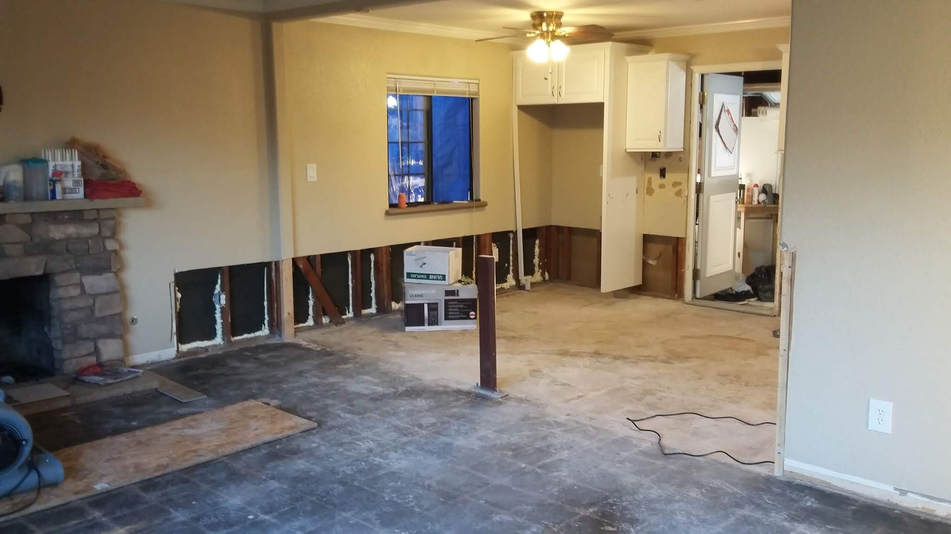 An empty living room with a fireplace and a window