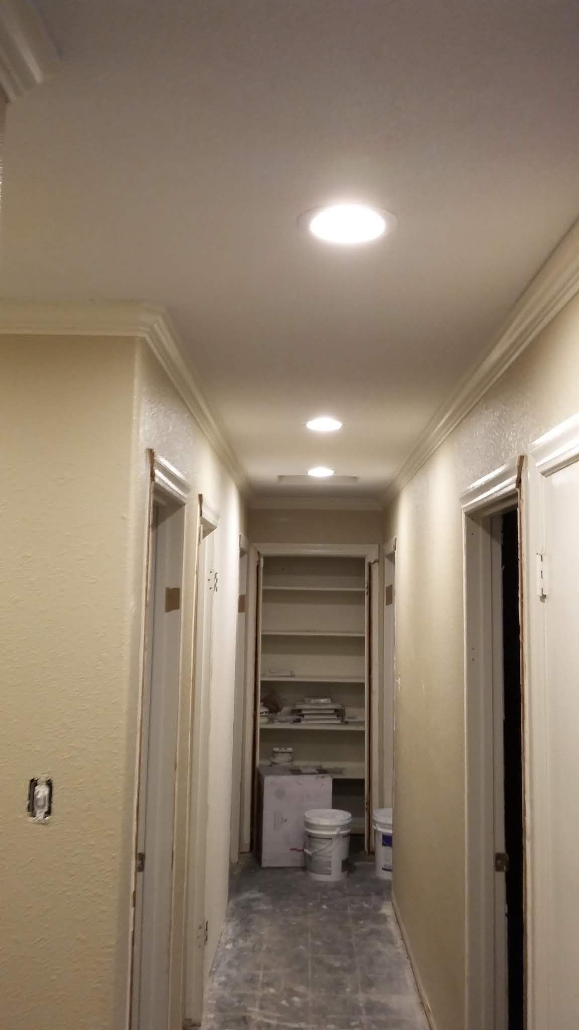 A long hallway with a ceiling light and a closet.