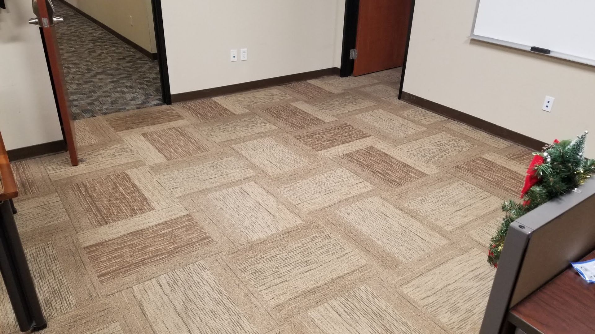 A room with a carpeted floor and a whiteboard.