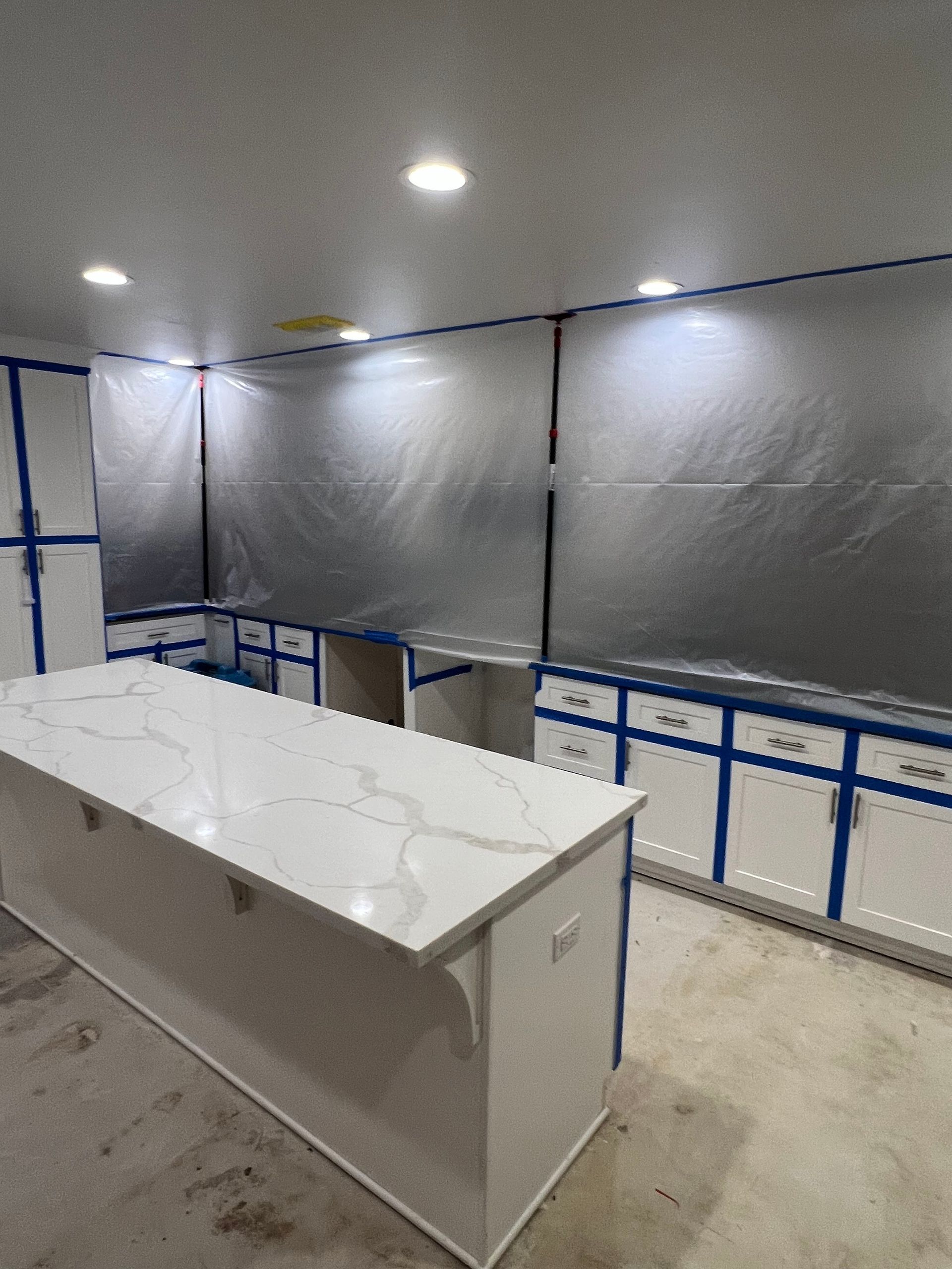 A kitchen with white cabinets and a large white counter top