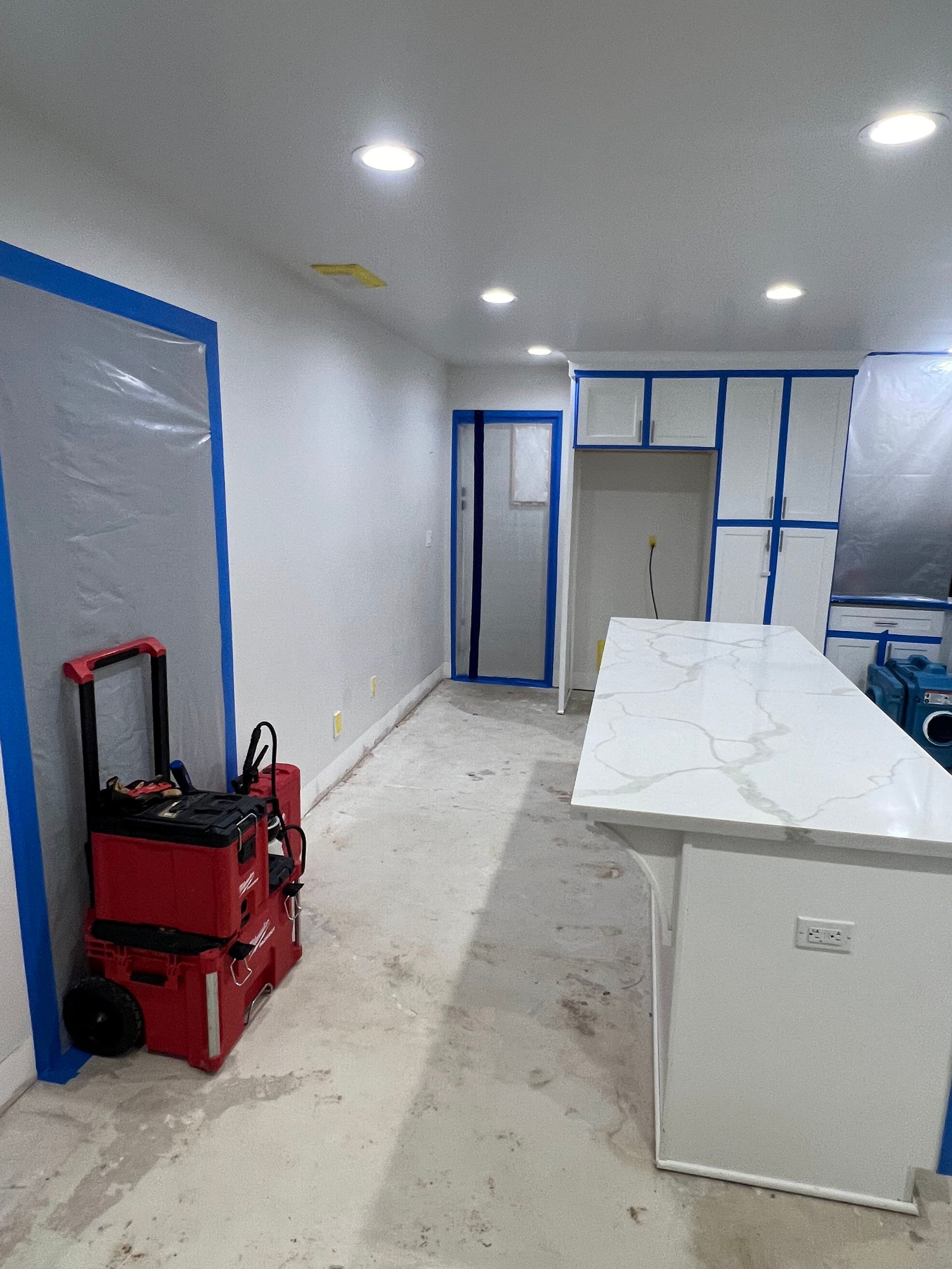 A kitchen under construction with a large island in the middle of the room.