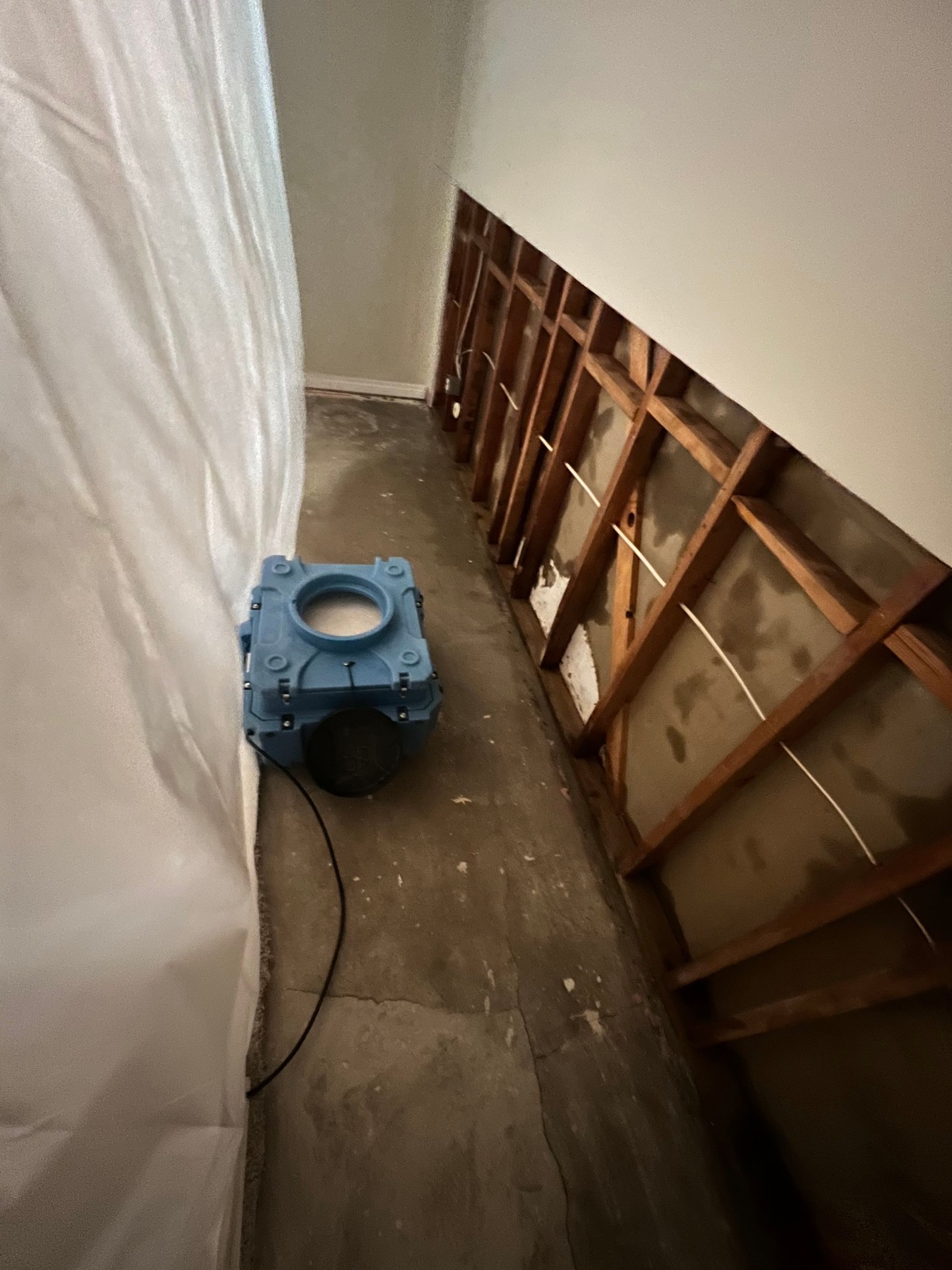 A blue box with a hole in the middle is sitting in a room with wooden beams.