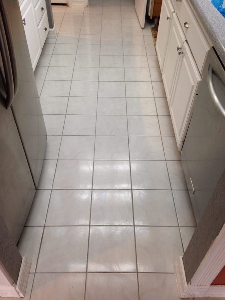 A kitchen with white tile floors and white cabinets