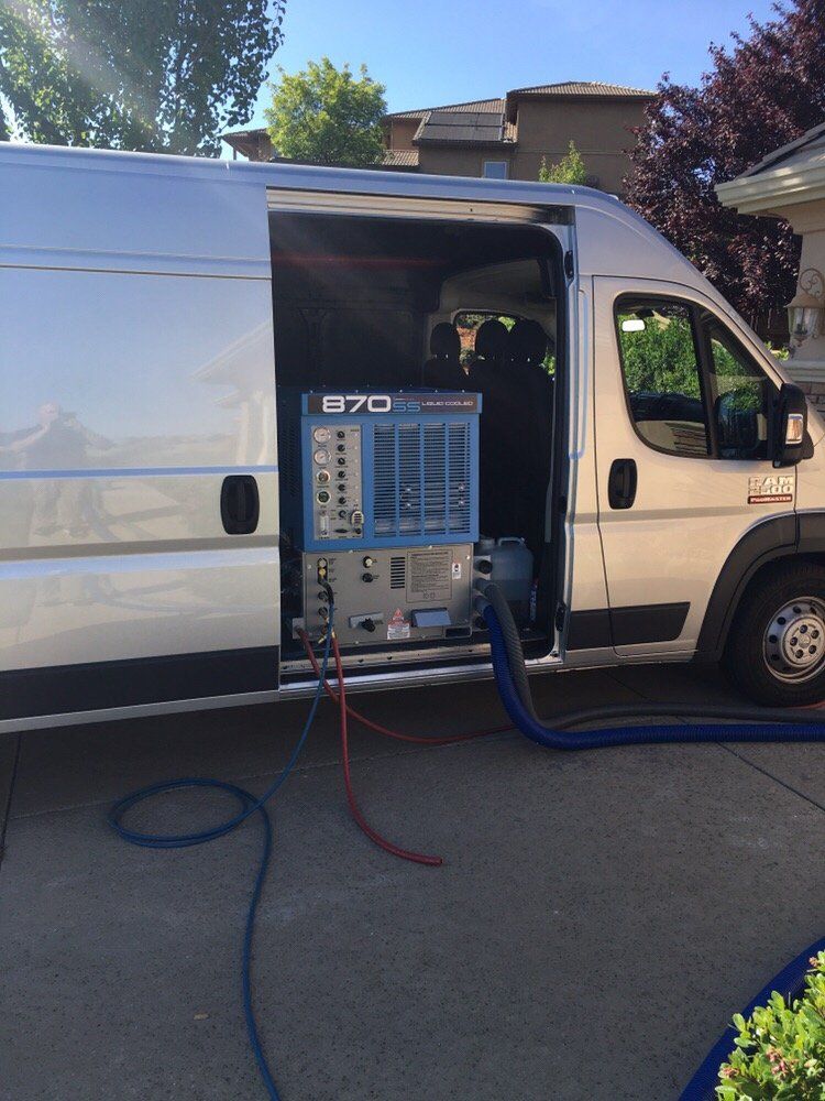 A van with the door open and a machine in the back that says 070