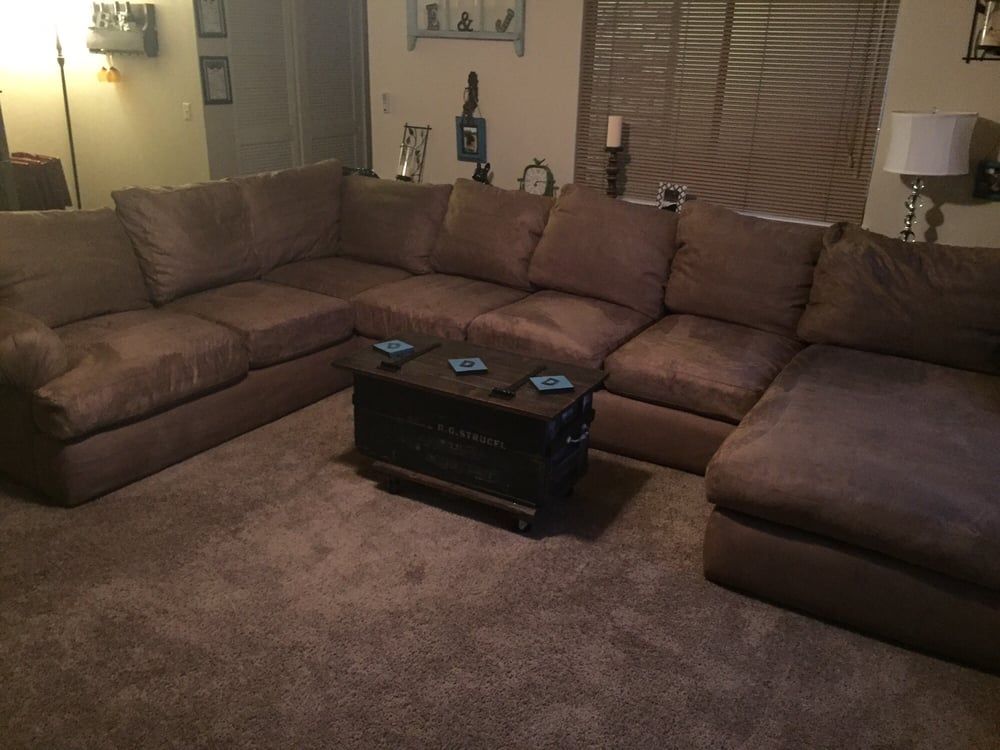 A living room with a large sectional couch and a coffee table