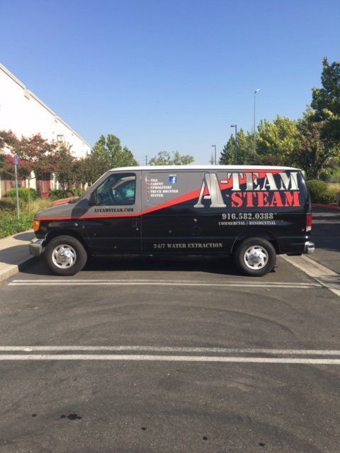 A team steam van is parked in a parking lot