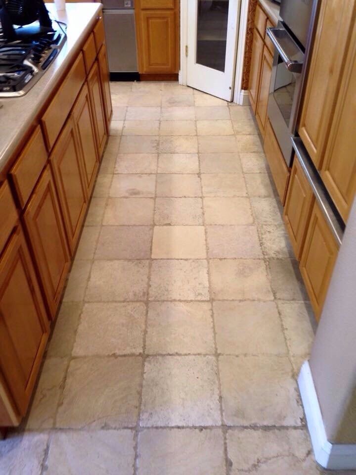 A kitchen with a tiled floor and wooden cabinets