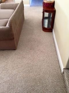 A living room with a couch , table , and carpet.