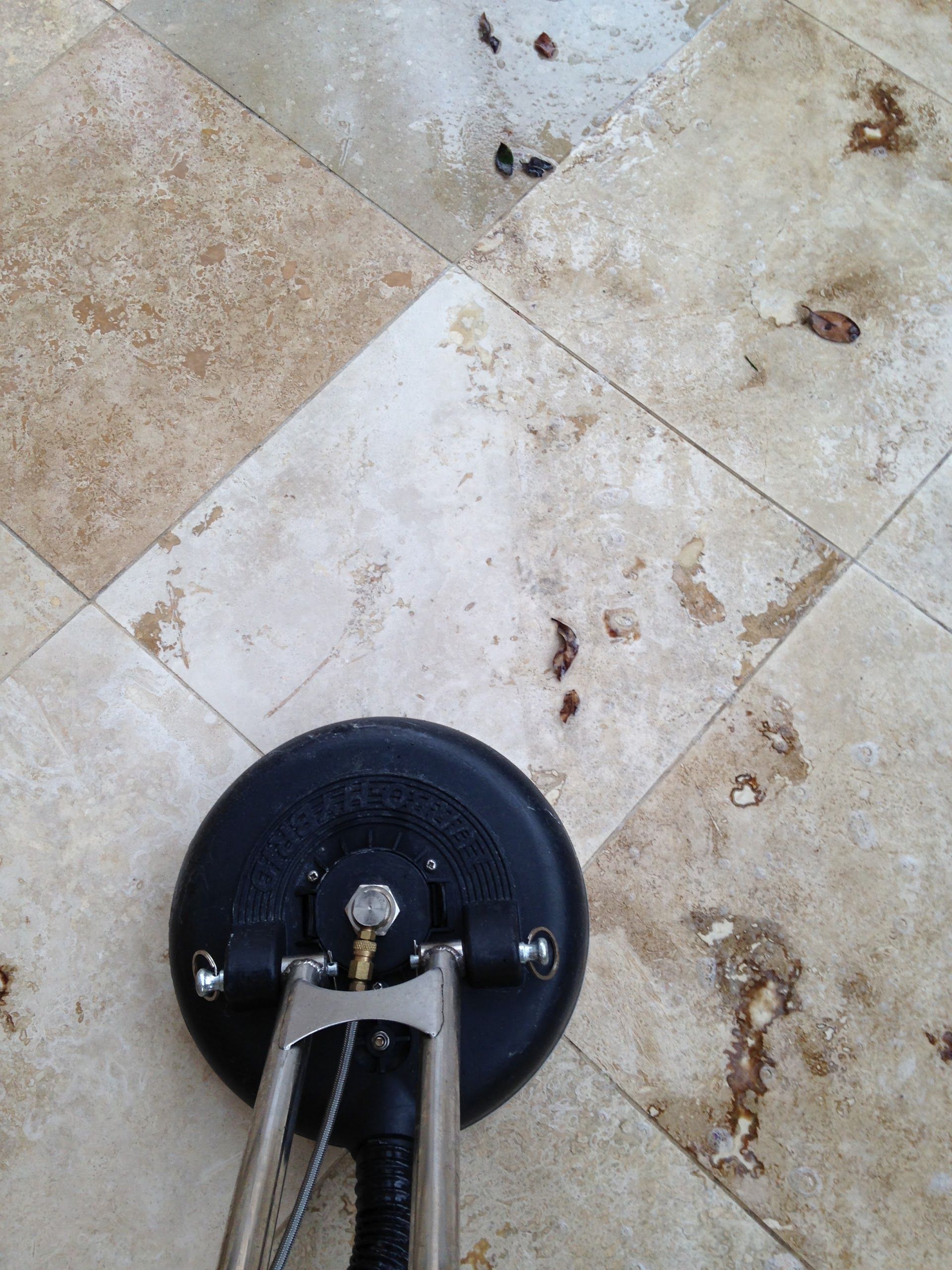 A dirty tile floor is being cleaned by a machine