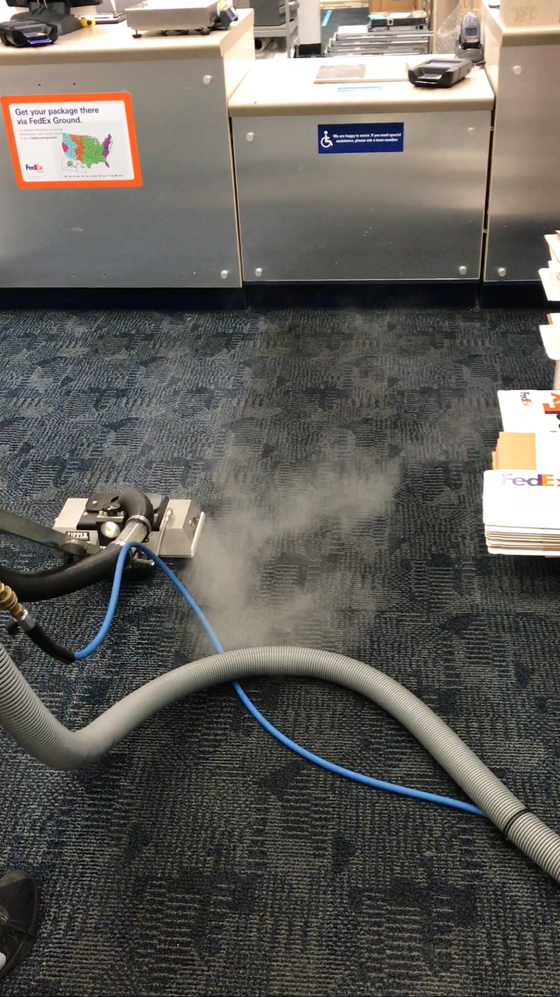 A vacuum cleaner is cleaning a carpet in an office.