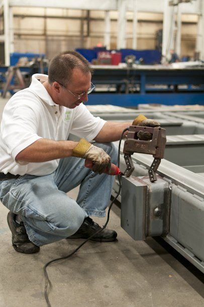 A man is working on a piece of metal in a factory