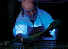 A man in an apron is working in a dark room