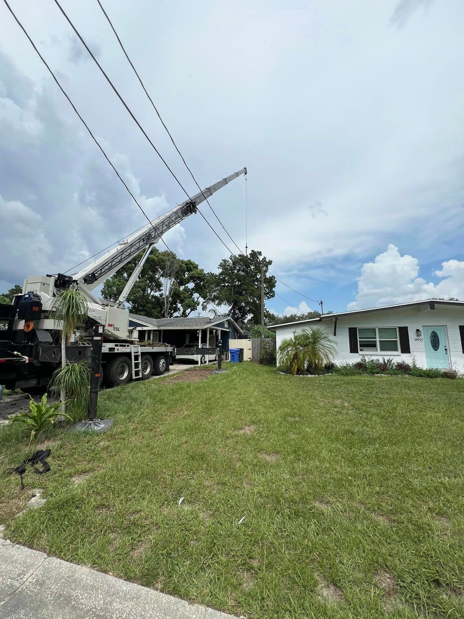 A large crane is sitting in front of a house.