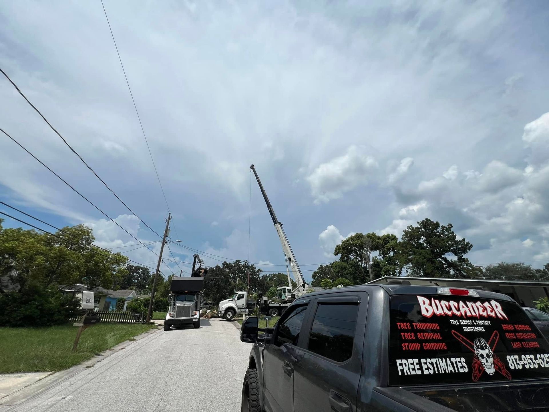 A truck is parked on the side of the road next to a crane.
