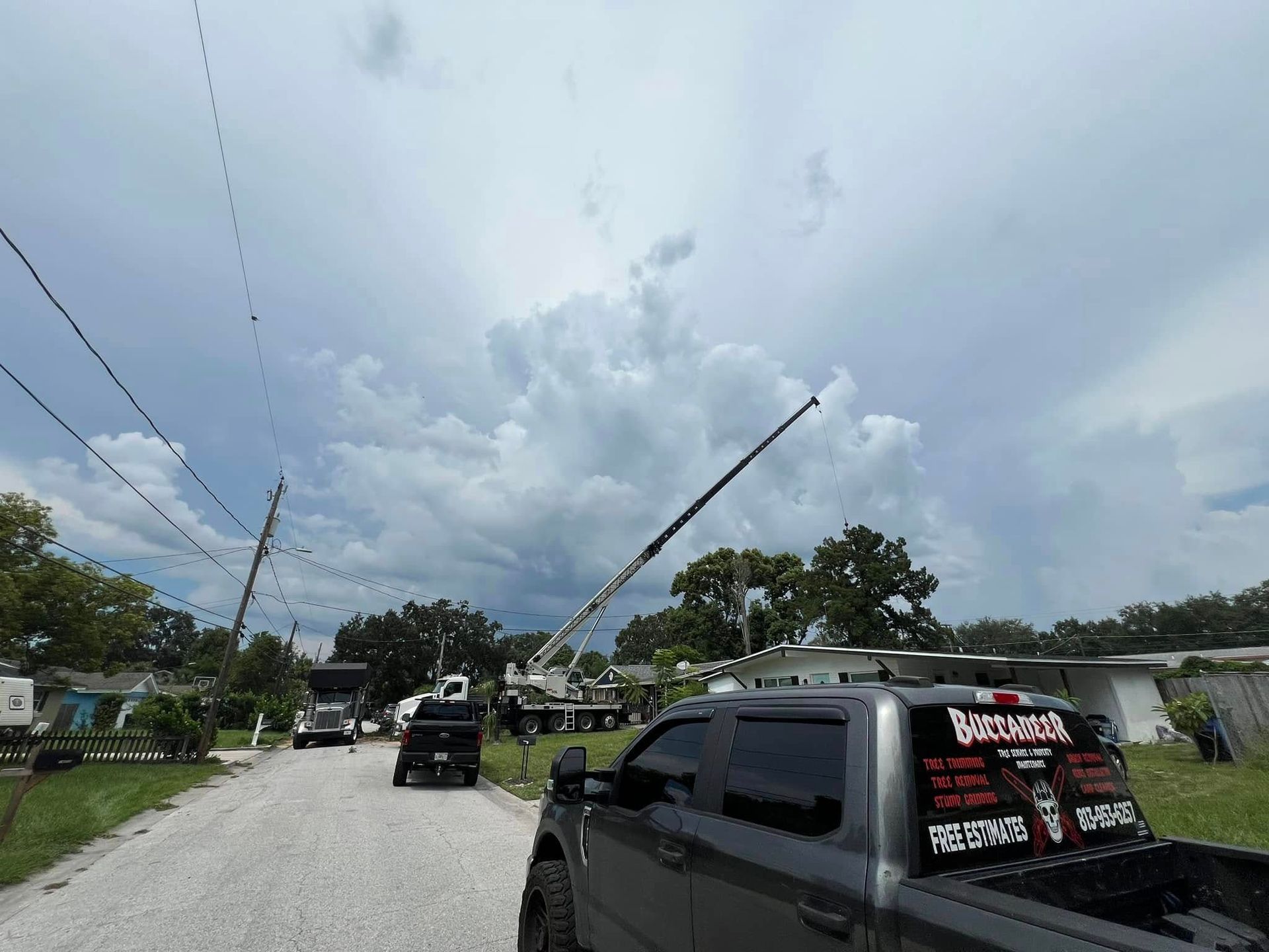 A truck is parked on the side of the road next to a crane.