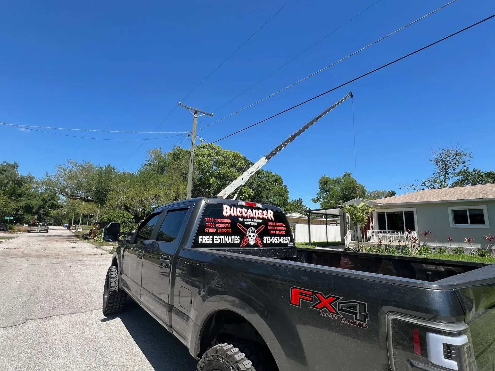 A black truck is parked in a driveway next to a house.