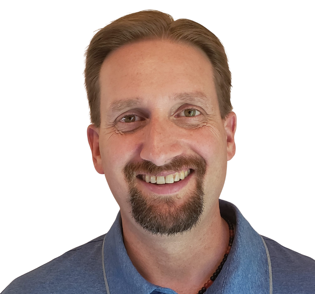 Smiling man in a blue collared shirt against a white background