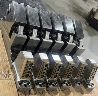 Um monte de blocos de metal estão em cima de uma mesa de madeira.