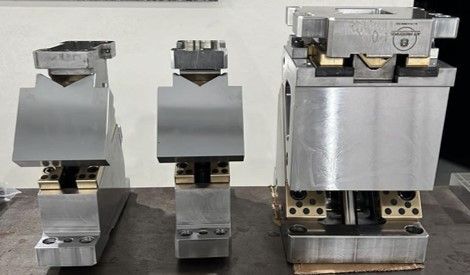 Três pedaços de metal estão sobrepostos em uma mesa.