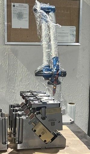 Uma máquina está embrulhada em plástico e colocada sobre uma mesa.