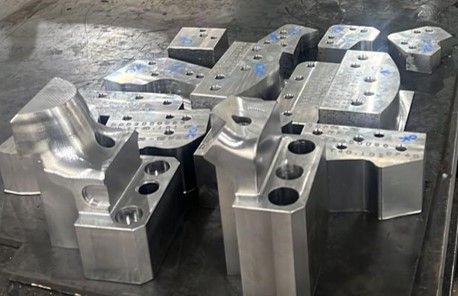 Um monte de peças de metal estão empilhadas umas sobre as outras sobre uma mesa.