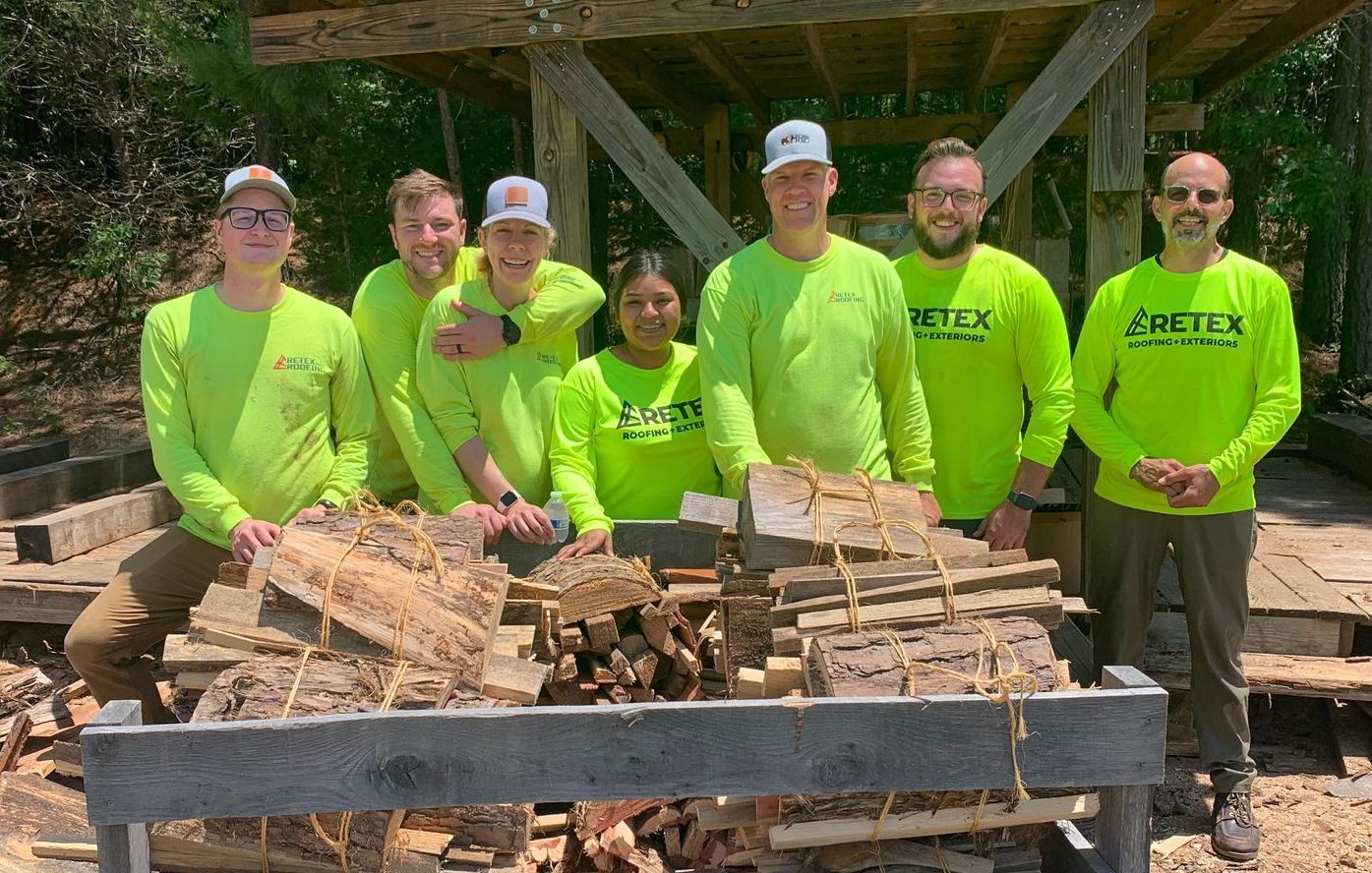 Image of RETEX team members behind crate full of bundled fireword from a Meno Life volunteer day in July 2023.