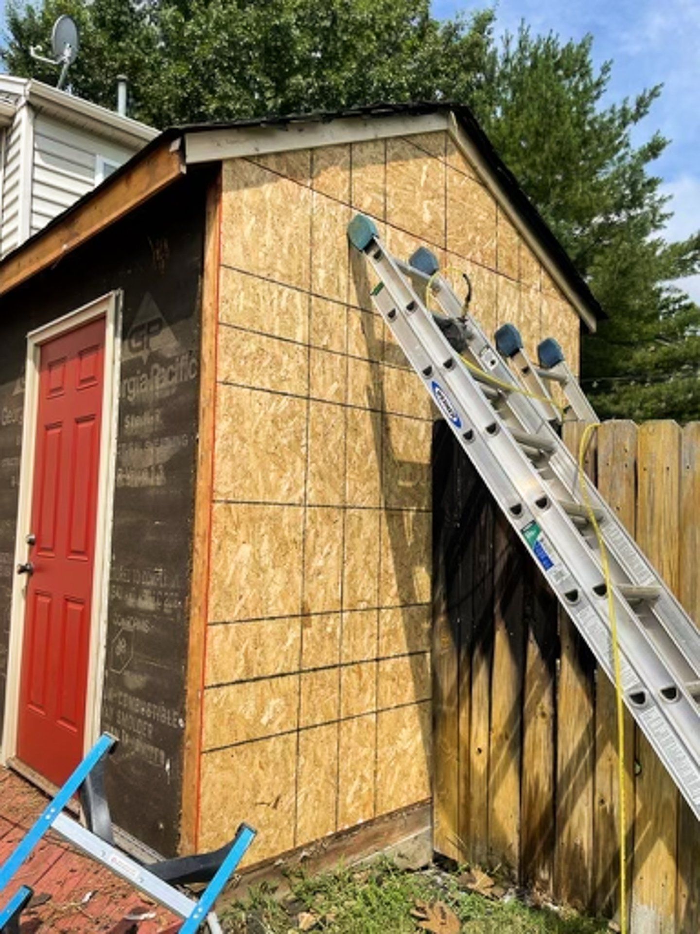 A during-install photo of a fire-damaged shed that RETEX replaced the siding, roof, and gutters for in Glen Allen VA.