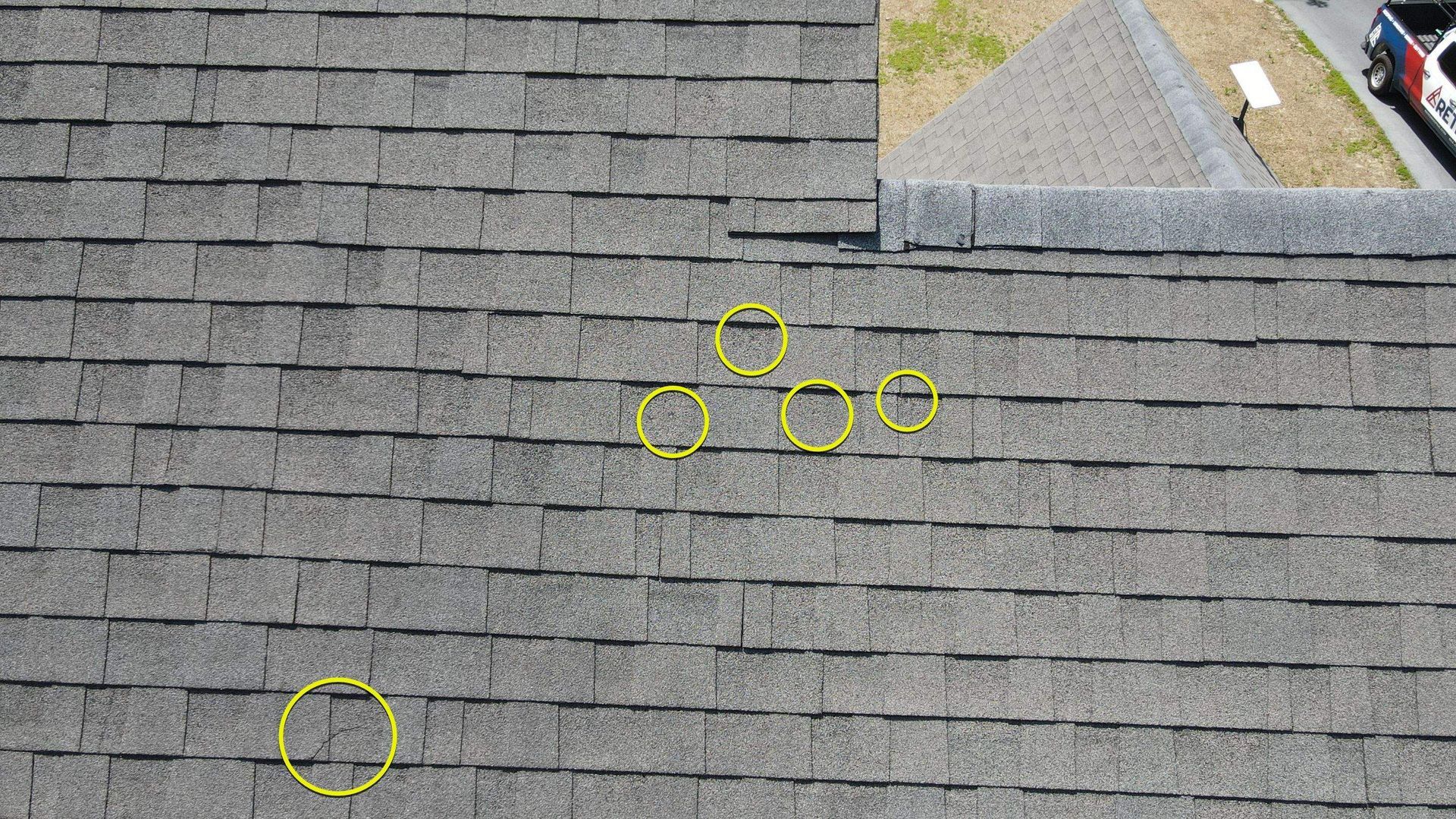 Image of roof during hail damage inspection by RETEX's Mark Erickson, with added yellow circles highlighting damaged areas.