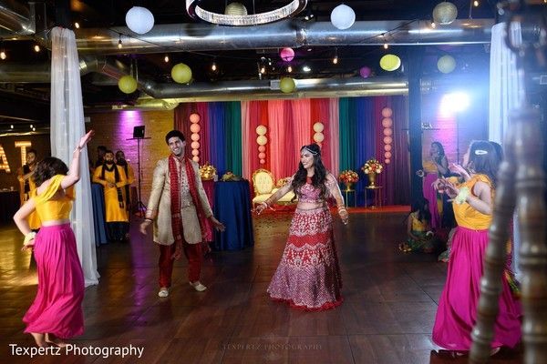A group of people are dancing on a dance floor in a room.