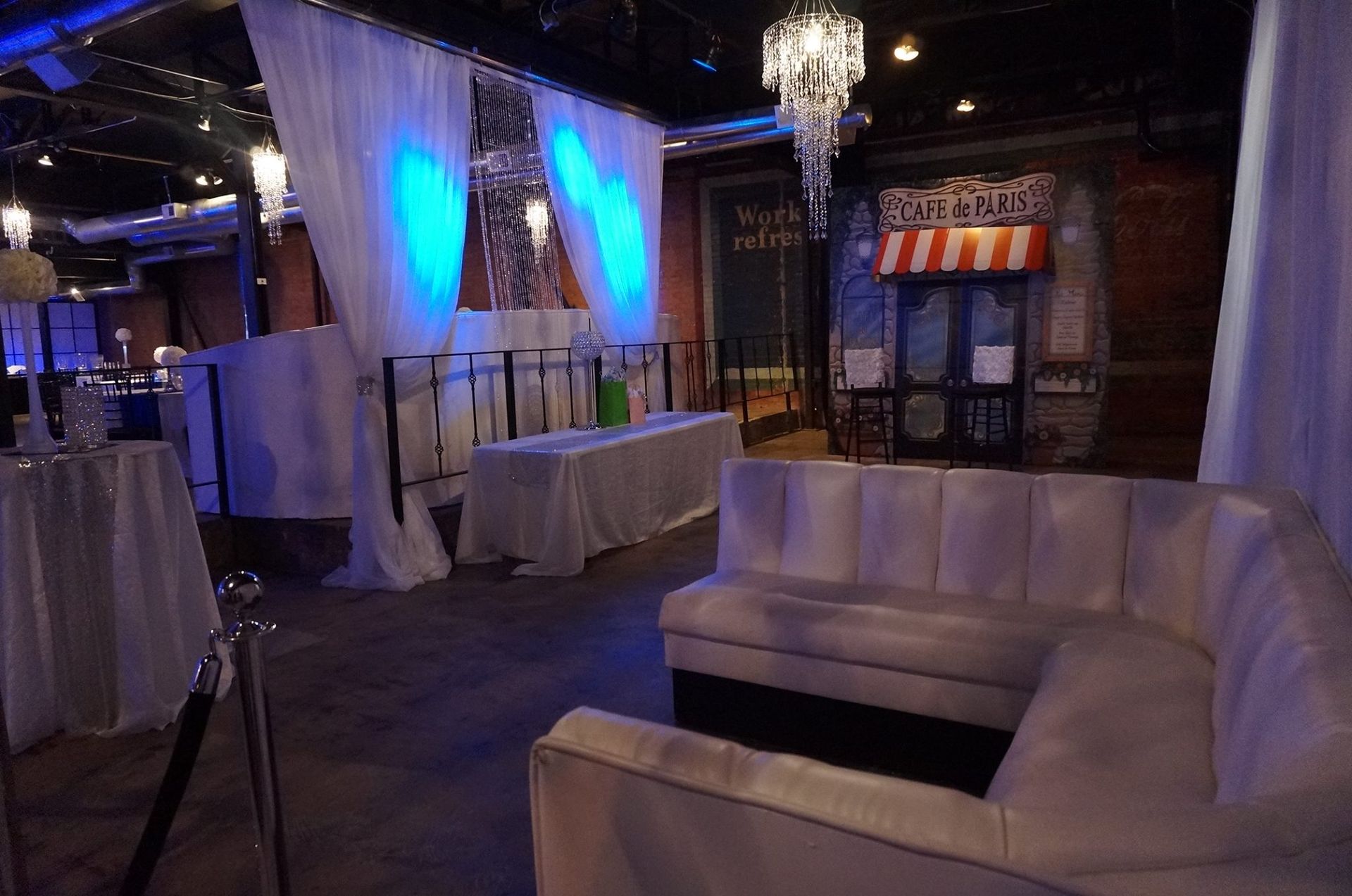 A large room with a couch , tables , and a popcorn machine.