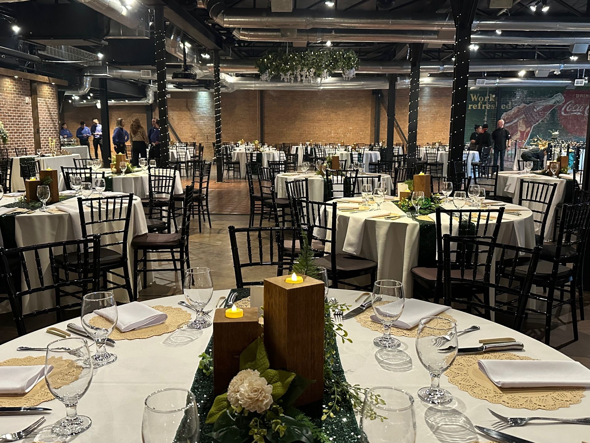 A large room with tables and chairs set up for a wedding reception.